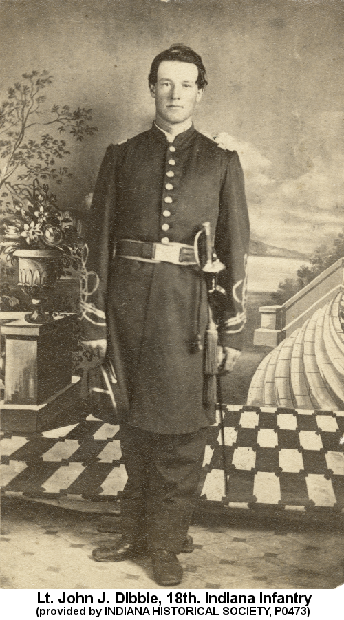 Sepia-tone photograph of a clean-shaven young man with slicked-back hair, wearing a full-dress Union Lieutenant's uniform, complete with sabre, standing before a painted backdrop of a classical setting